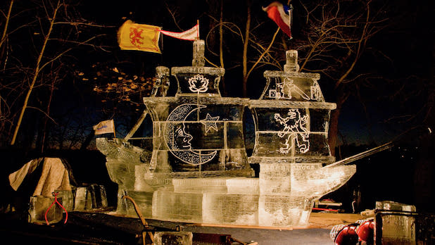 An ice sculpture of a pirate ship illuminated at night