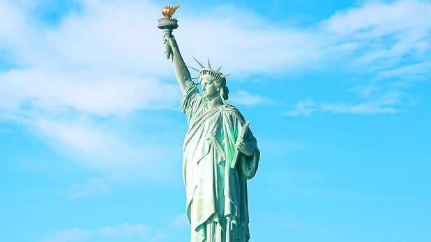 Clouds float behind the Statue of Liberty