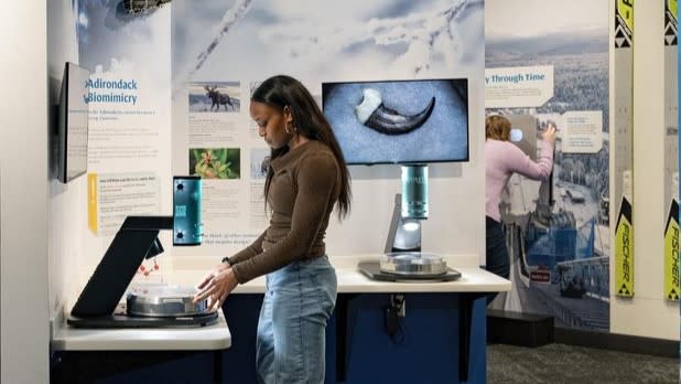 a woman explores the "Snow on Demand" exhibit at  the Lake Placid Olympic Museum