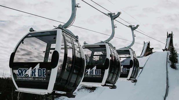 Three cabins of the Olympic Jumping Complex Skyride Experience with the ski jump towers in the background