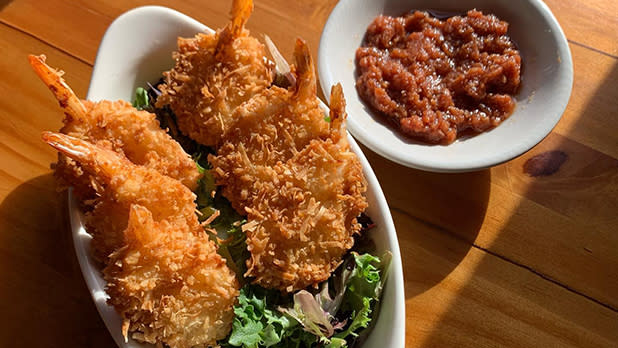 A plate of coconut shrimp with a dipping sauce on the side at Lock Stock Bar & Grill