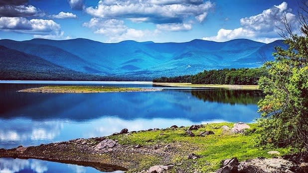 Rolling hills of the Catskill Mountains seen beyond the crisp blue waters of Ashokan Reservoir