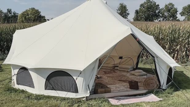 A giant white tent with blankets and pillows inside
