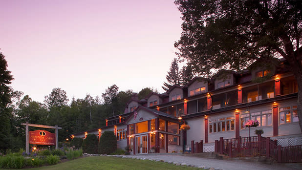 White house with brown roof and glowing orange lights at sunset