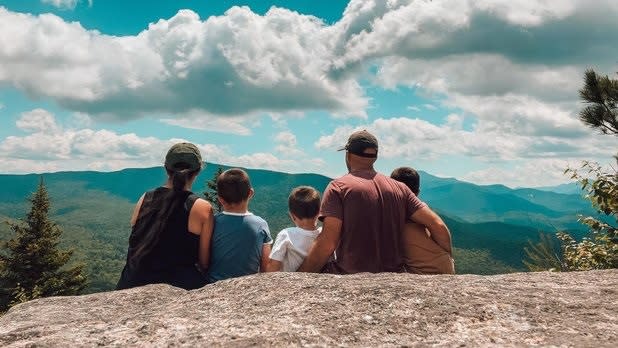 A family of five sitting on an overlook on Big Crow Mountain