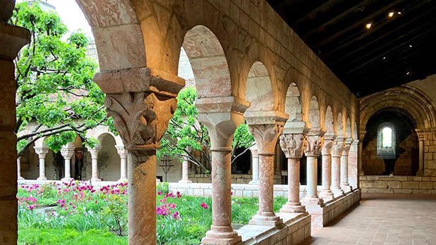 Flowers and greenery visible through Medieval arches
