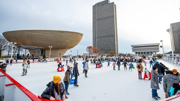 People skating on the ice rink at Empire State Plaza in front of The Egg in Albany