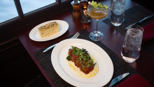 An elegant entree, cocktail, and side of bread on a set table at the Otesaga Hotel in Cooperstown