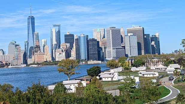 View of the city skyline among the trees and green space at Governors Island