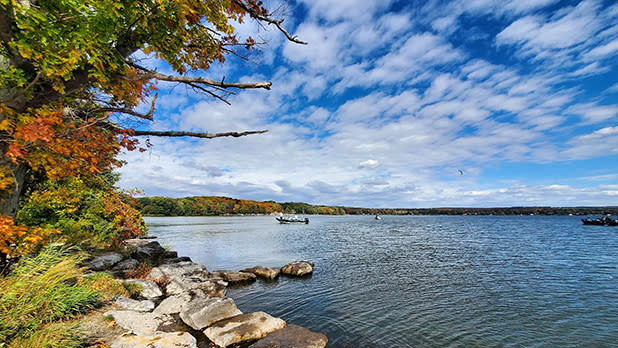 View of Chautauqua Lake with two boats in the water as seen from the rocky shoreline