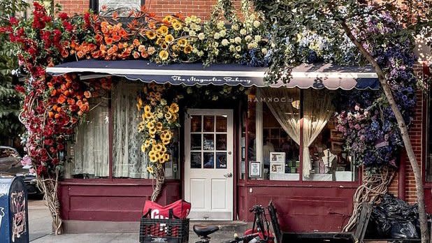 Magnolia Bakery on Bleecker Street storefront framed with a rainbow of flowers