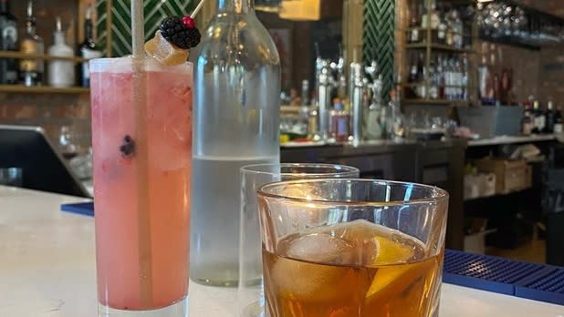 A tall pink mocktail and short amber mocktail
