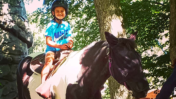 Photo of a young person riding a horse at rocking horse ranch
