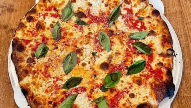Cheese pizza with green basil leaves
