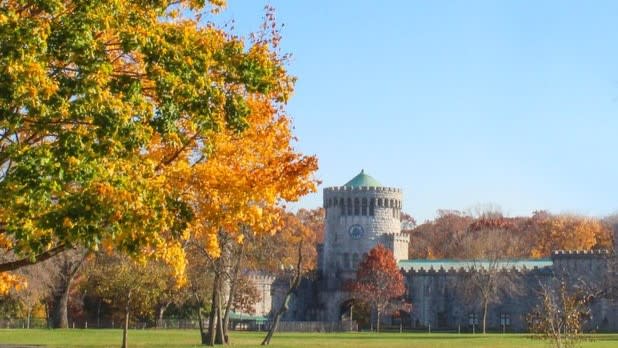 A castle at Sands Point Preserve surrounded by trees with orange and green leaves