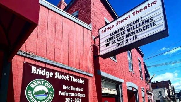 A sign that reads "Bridge Street Theatre" displays upcoming shows in front of the exterior of the Bridge Street Theatre