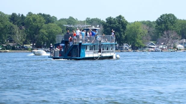 the blue and white historic Mississippi River Boat, the Rose Lummis floating in Sodus Bay