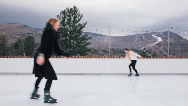 two people ice skating with the Catskill Mountains in the background