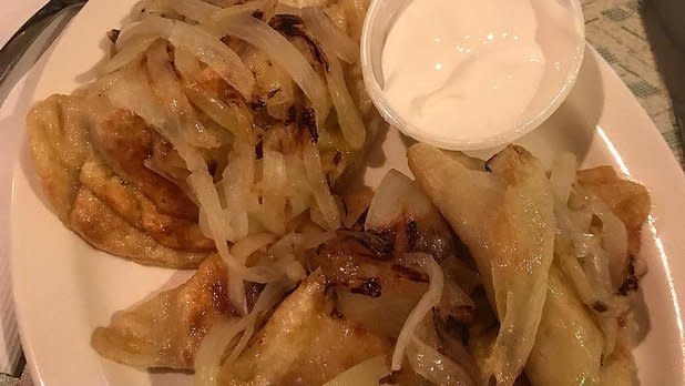 A plate of Pierogies with onions and sour cream