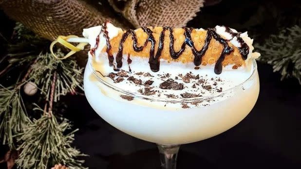 Cocktail glass with festive winter drink in front of festive background