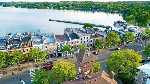 An aerial view of Downtown Skaneateles in front of Skaneateles Lake in summer