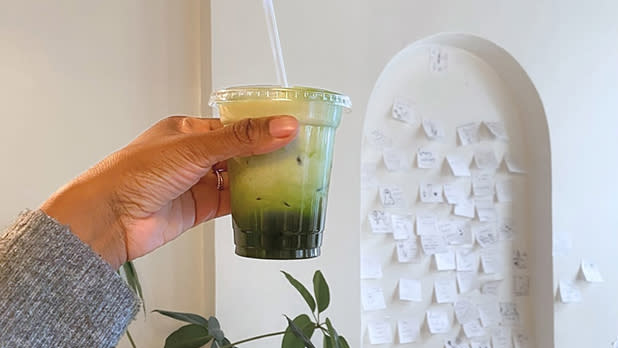 A hand holding up a cup of salted maple matcha from Matcha Thomas in Beacon
