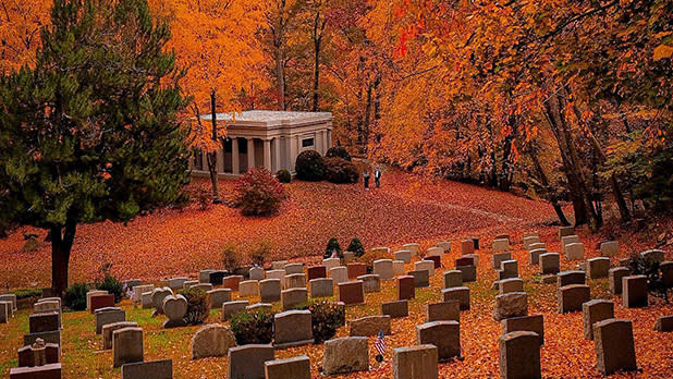 Rich orange leaves blanket Sleepy Hollow Cemetery in the fall