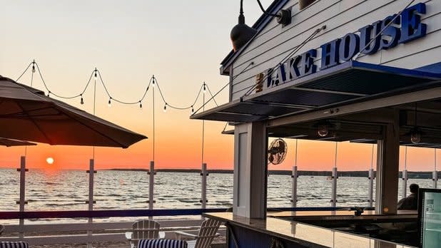 View of the sun setting over Oneida Lake from the patio at a bar restaurant at The Cove at Sylvan Beach in Central New York