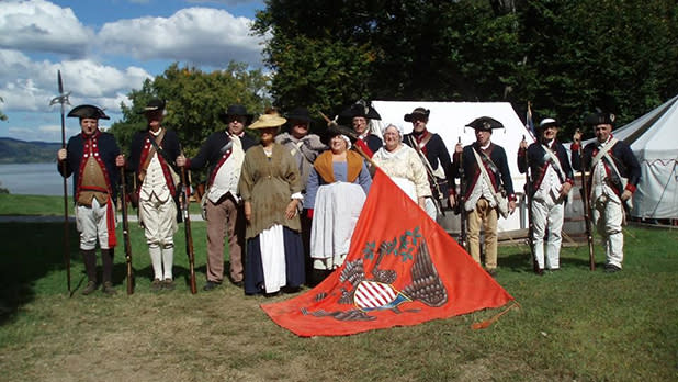 Revolutionary War reenactors dressed in military garb pose for a photo at Stony Point Battlefield State Historic Site