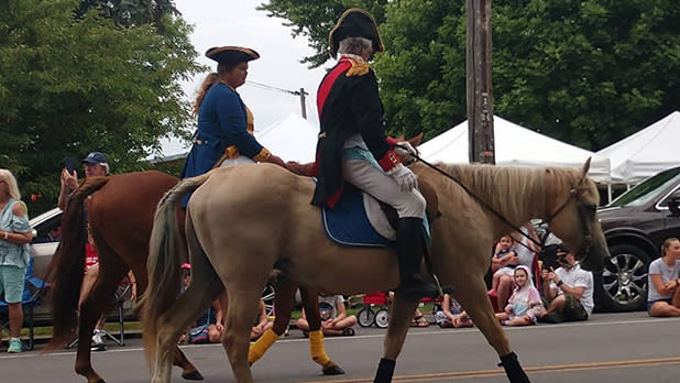 Two people dressed in historic French uniforms on horseback at Cape Vincent's annual French Festival