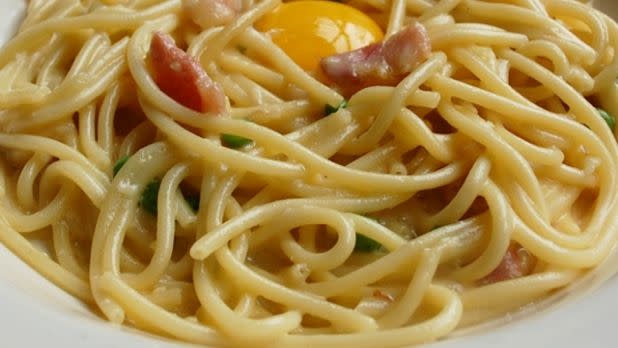 Spaghetti carbonara with egg, bacon and herbs