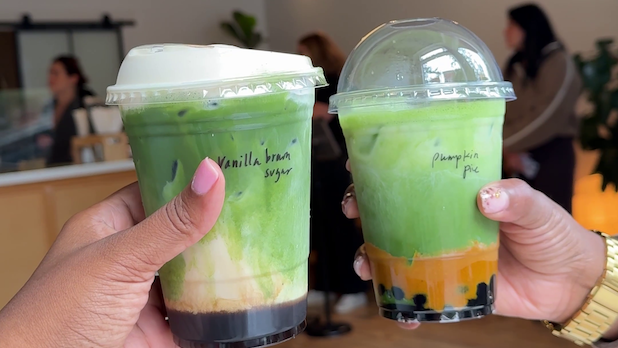 POV of two people cheers-ing matcha lattes from Matcha Thomas in Beacon, NY