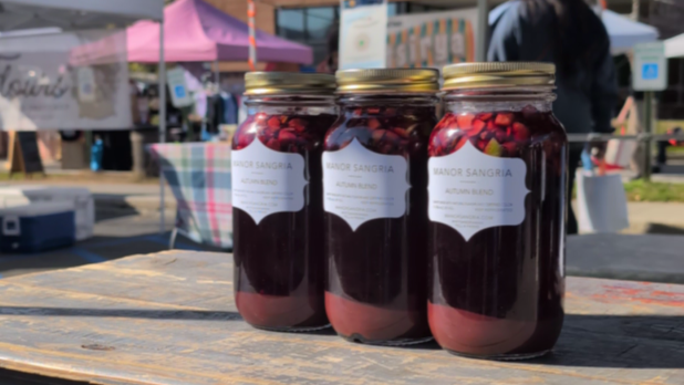 Jars of Manor Sangria on display on a wooden table at Beacon Farmers Market