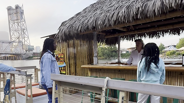 Two girls stand on a tiki boat in Buffalo Harbor