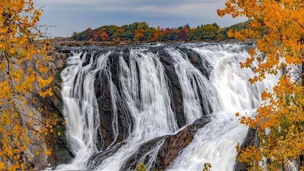 Water flowing down jagged rocks surrounded by fall foliage