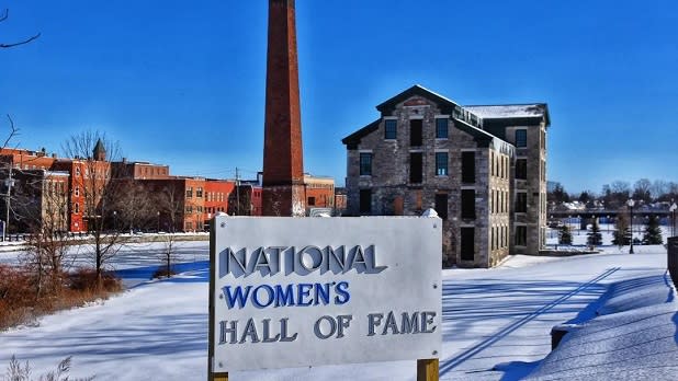A white sign stands at the entrance to the snowy grounds of the National Women's Hall of Fame