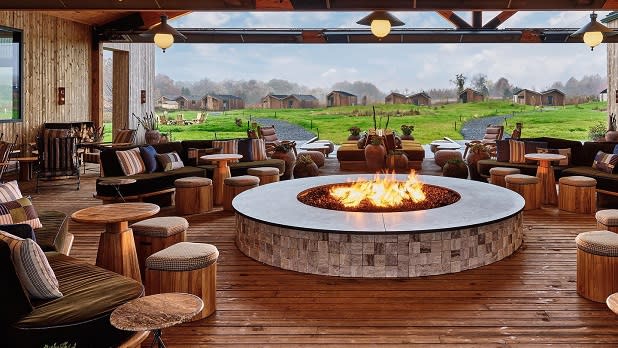 Flames shoot out of a welcoming fire pit inside the great porch at the Wildflower Farms resort