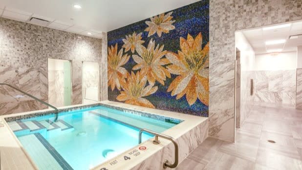 A hot tub with a mosaic of flowers in the background