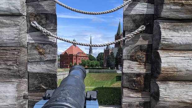 a view of historic buildings looking out over a cannon