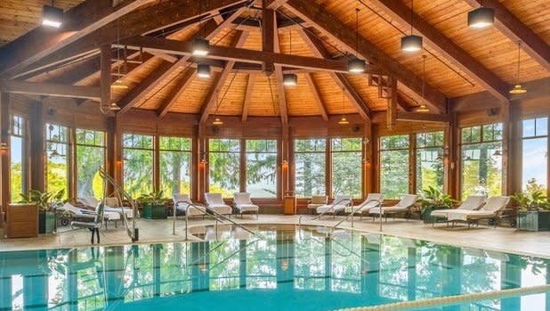 interior of the Mohonk Mountain House pool with a bright wooded ceiling and vibrant blue pool surrounded by lounge chairs