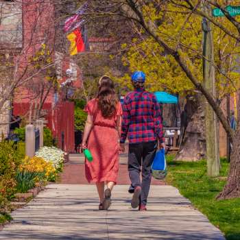 Man and woman holding hands, walking on German Village sidewalk in the spring