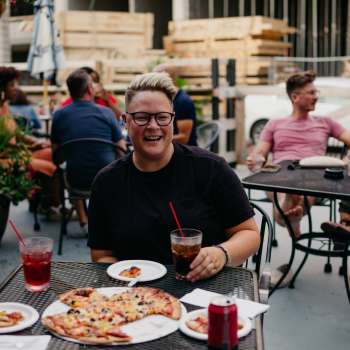 Woman eating Columbus-Style Pizza at Slammers in Columbus