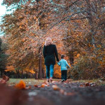 Mother and son holding hands during a walk in the fall