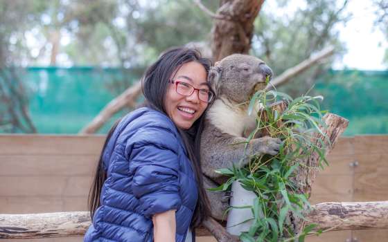 Female tourist taking selfie with a koala at Moonlit Sanctuary Wildlife Conservation Park