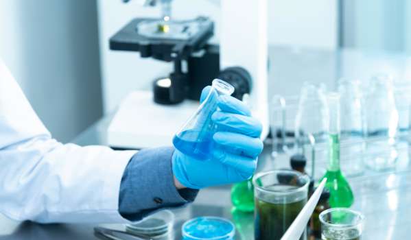 Scientist holding a test tube with blue fluid