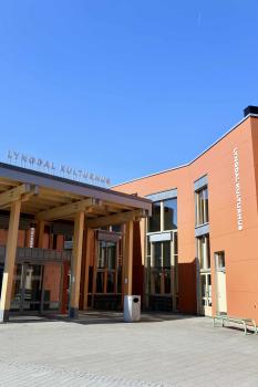 Fasaden til Lyngdal kulturhus under blå himmel.