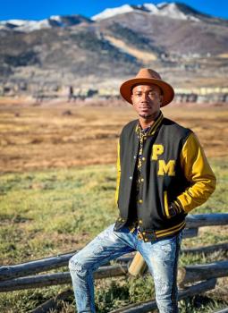 Revice Jordan of POSH posing in front of a mountainous backdrop