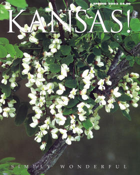 magazine cover with the word "KANSAS!" across the top. The image is of small white tree blossoms surrounded by green leaves