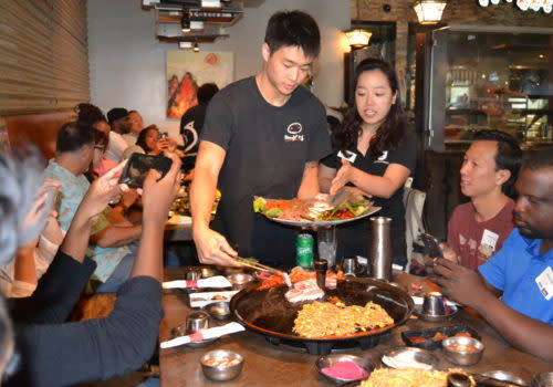 people serving korean bbq