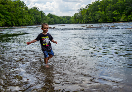 boy wading through lake